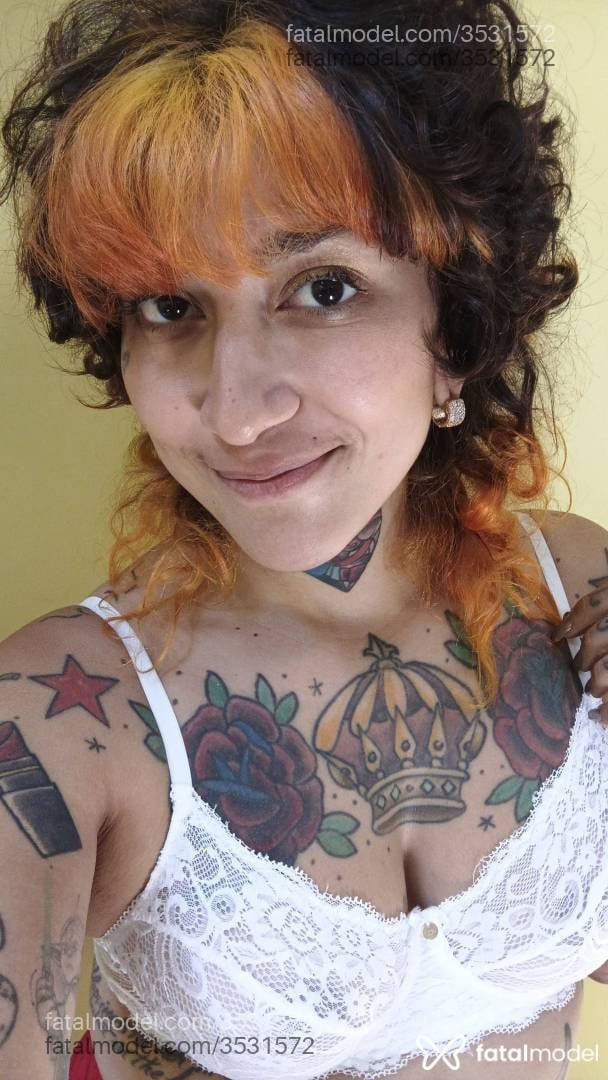 Acompanhante não-binário com cabelo colorido de olhos castanhos - Amora