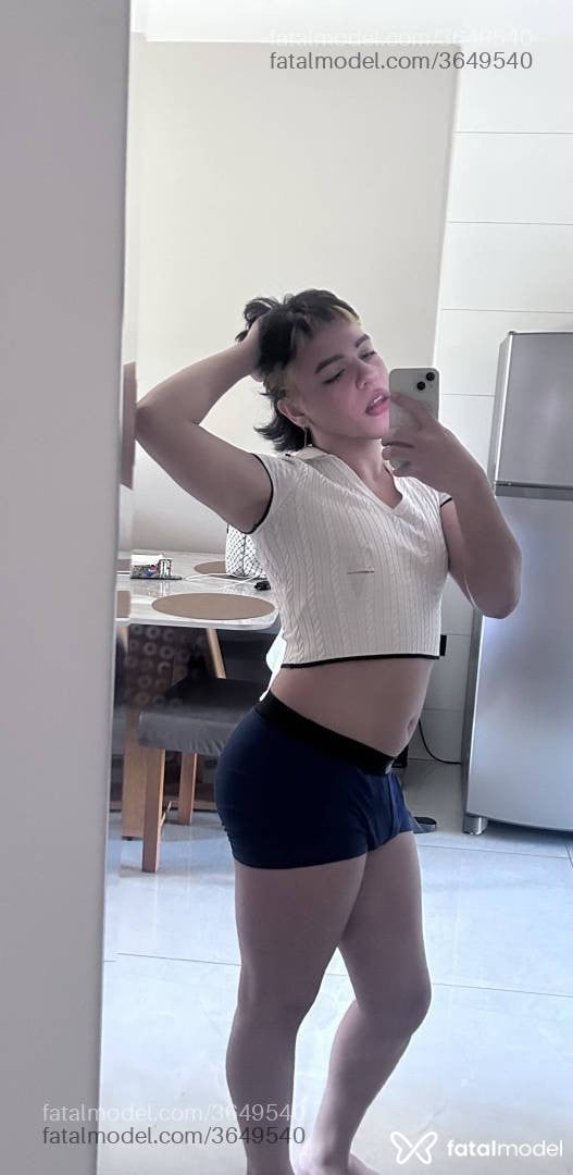 Acompanhante não-binário com cabelo colorido de olhos castanhos - Hanna